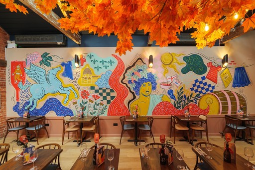 Warm Zizzi Winchester interior with vibrant décor and art murals on wall.