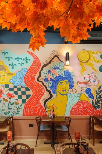 Warm Zizzi Winchester interior with vibrant décor and art murals on wall.