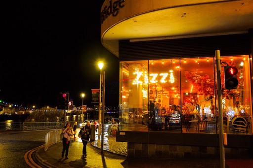 Zizzi Inverness at night, open-plan dining with full-height windows overlooking the River Ness.