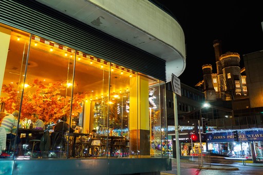 Zizzi Inverness at night, open-plan dining with full-height windows overlooking the River Ness.