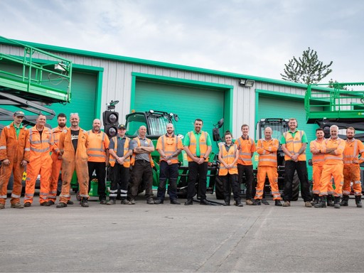 Group photo of a Sunbelt Rentals depot team standing outside the depot with equipment in the background.