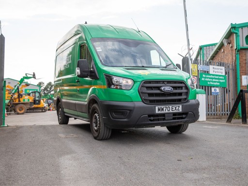 Sunbelt Rentals branded green Ford Transit van leaving a depot yard.