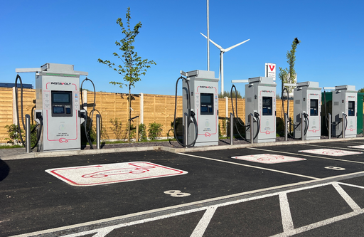 Angled view of InstaVolt charging hub showing ultra rapid units, bay markings and nearby industrial setting
