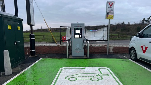 An InstaVolt rapid EV charger at a roadside site, featuring a green-marked parking bay and a visible charger unit ready for electric vehicle charging.
