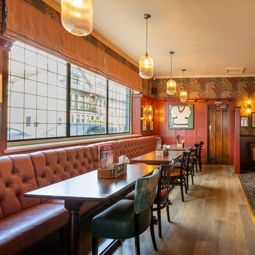 A comfortable dining area inside The Victoria Park Hotel with booth seating, tables and warm lighting, ideal for relaxed meals and casual visits.