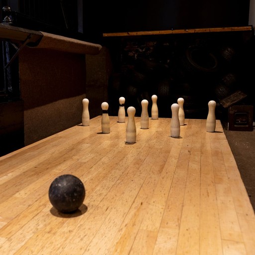 A traditional indoor bowling alley at The Victoria Park Hotel, featuring a wooden lane, skittles and bowling ball, offering a classic pub game for groups and social visits.