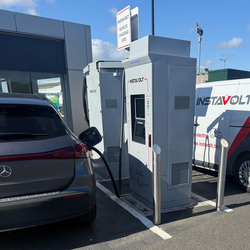 A Mercedes electric vehicle charges at InstaVolt’s ultra rapid EV chargers located in McDonald's Middlesbrough, next to a modern building with clear branding and signage.