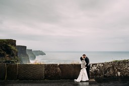 wedding couple kissing in front of cliffs of moher