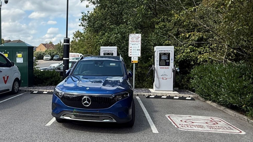 A Mercedes EQB is parked at an InstaVolt EV charging station surrounded by greenery, with two rapid chargers available for use. Clear signage and EV bay markings are visible, offering easy access for drivers.