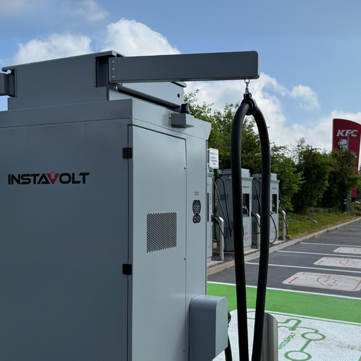 A detailed close-up of an InstaVolt ultra rapid charger shows cable management and connector ports, set against the backdrop of the charging bay layout. The nearby KFC signage highlights a convenient food option for EV drivers while charging at the Wincanton A303 location.