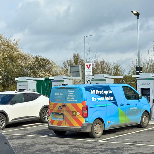 Active charging bays with vehicles parked near on site facilities and services.