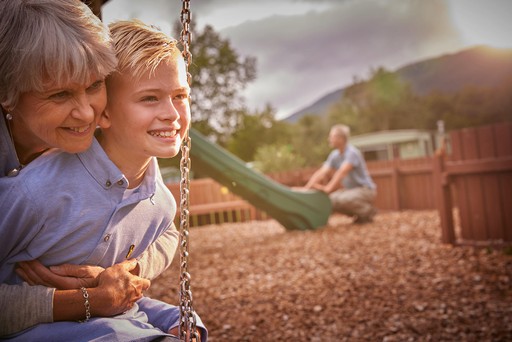 Grandparents play with their grandchildren in the outdoor play area at Stratheck