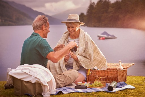 Retired couple enjoy a picnic on the banks of Loch Eck at Stratheck