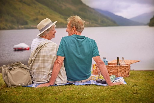Retired couple enjoy a picnic on the banks of Loch Eck at Stratheck