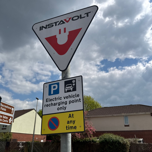 A roadside sign highlights InstaVolt’s EV charging point designation and parking rules, located near Culm Valley Sports Centre with visible wayfinding to nearby amenities.