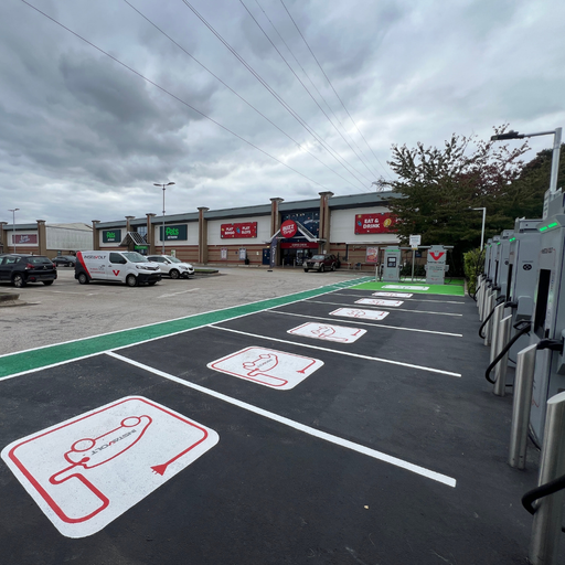A row of InstaVolt ultra-rapid chargers positioned near Buzz Bingo and Pets at Home in Stafford. Clearly marked bays and InstaVolt vans highlight a well-maintained EV charging area within a busy retail car park.