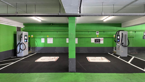 InstaVolt ultra-rapid EV chargers located in a brightly lit, green-painted indoor car park, featuring two clearly marked charging bays for electric vehicles.