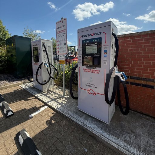 A clear view of InstaVolt’s ultra-rapid chargers installed at Sorbonne Close, Thornaby, showing accessible plug types and simple tap-to-pay functionality near a fenced area.