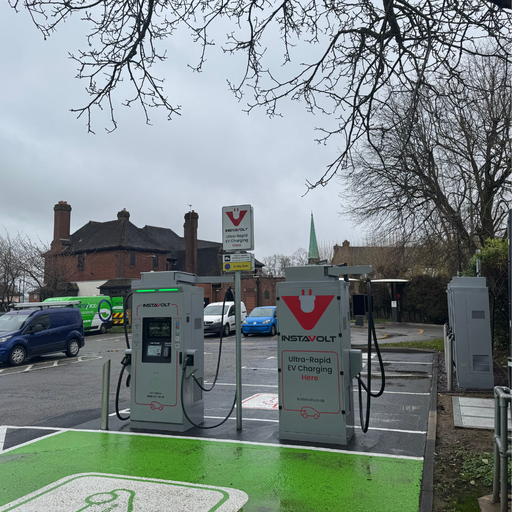 Side view of InstaVolt chargers showing nearby road access, surrounding buildings, and EV charging bays