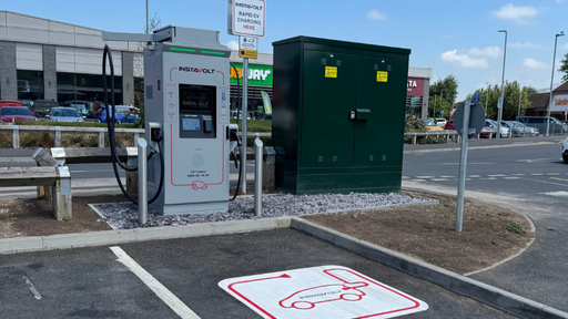 The image shows an InstaVolt rapid electric vehicle charger located at Gallagher Retail Park in Bridgwater. The charging unit is positioned in a marked bay, with clear signage and directional pavement graphics.