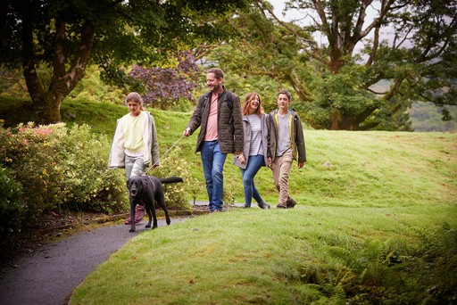 Family take a stroll with their dog through the grounds of Drimsynie Estate