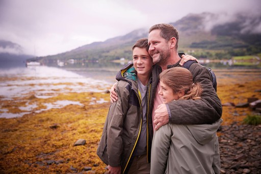 Father hugs his children while out walking the grounds of Drimsynie Estate
