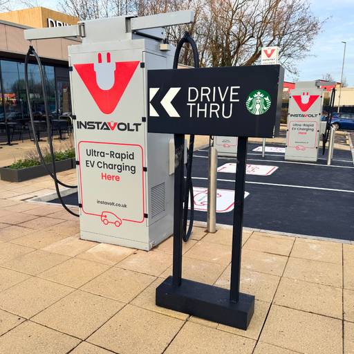 A close-up view of an InstaVolt charger located next to a drive thru sign at Starbucks, highlighting convenient access for EV drivers.