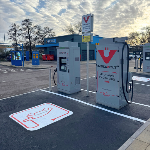InstaVolt ultra rapid chargers with clearly marked EV bays positioned near a Greggs and Starbucks offering added convenience for drivers stopping on Port Road, Newport.
