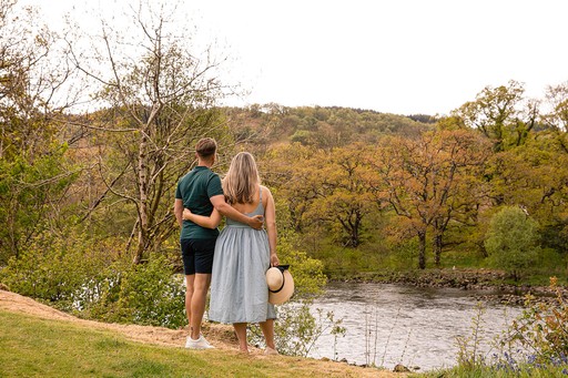 Couple enjoying the view of the river and surrounding woodlands of Loch Awe Holiday Park