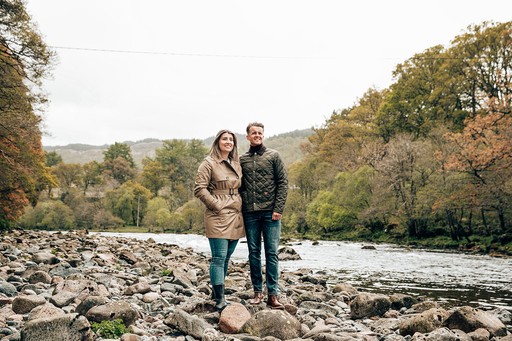 Couple stroll along the river bank at Loch Awe Holiday Park