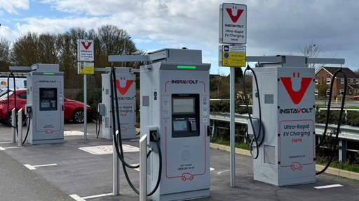 Wide view of InstaVolt charging station at Tesco Express with several ultra-rapid chargers and marked parking spaces