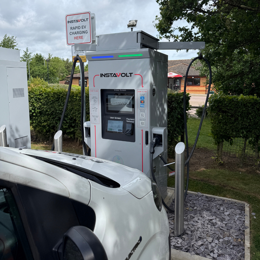 InstaVolt ultra rapid charger in action, set beside trees and roadside facilities.