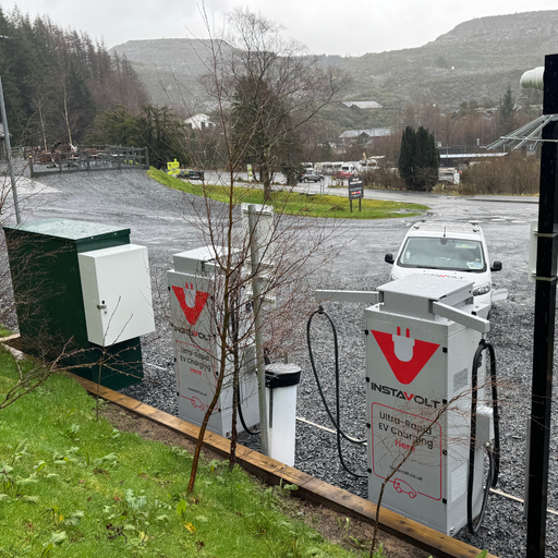 Elevated view of the InstaVolt charging units at Plas Weunydd Hotel, set against the Snowdonia hills with on site parking and surrounding greenery.
