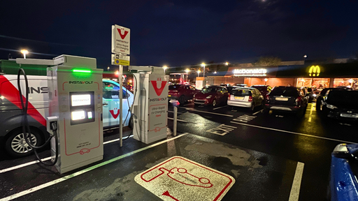 The image shows InstaVolt ultra-rapid chargers in use outside McDonald’s in Ashington during nighttime. The charging bays are clearly marked, and the restaurant is well-lit in the background, providing convenient access to food while EV drivers charge their vehicles.
