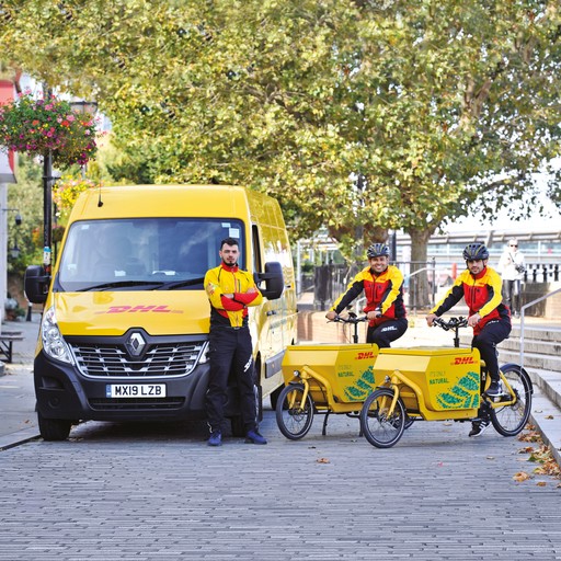 DHL Express couriers with a yellow-branded van and two cargo bikes parked on a cobblestone street, showcasing eco-friendly urban delivery solutions.