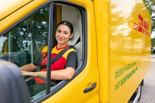DHL Express courier seated inside a yellow delivery van, wearing a red and yellow DHL uniform and secured with a seatbelt.