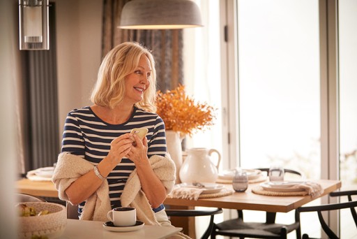 Lady relaxes at the kitchen table of her lodge at Loch Lomond