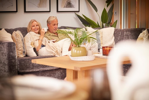 Couple relax in the living area of their lodge at Loch Lomond