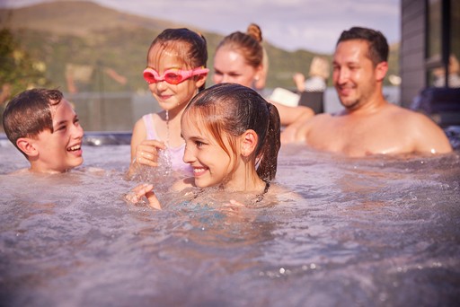 Family having fun in their lodges Hot Tub at Loch Lomond Holiday Park