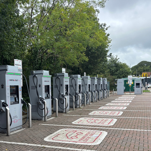 A long row of InstaVolt ultra rapid EV chargers at Bodmin Retail Park, with clear bay markings and nearby McDonald’s in view.