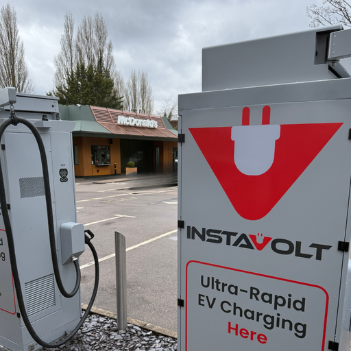 Close-up of InstaVolt ultra rapid EV charging unit and signage with McDonald’s restaurant visible in the background in Norwich.