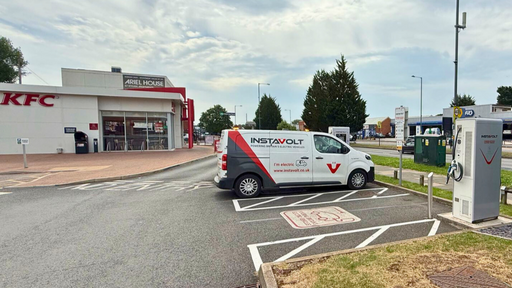 An InstaVolt-branded electric van charging at ultra rapid EV charging stations located in the car park of KFC Sheldon on Coventry Road, Birmingham. The chargers are clearly marked with a “Rapid Charge Here” sign, and the KFC building is visible in the background.