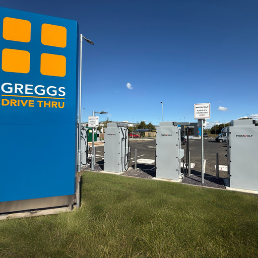 A row of InstaVolt ultra-rapid EV chargers situated next to the Greggs Drive Thru sign at Skimmingdish Lane in Bicester, offering convenient charging for electric vehicle drivers.